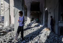 Palestinians inspect destroyed building after Israeli airstrike in Gaza City