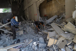 Palestinians inspect destroyed building after Israeli airstrike in Gaza City