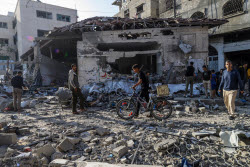 Palestinians inspect destroyed building after Israeli airstrike in Gaza City