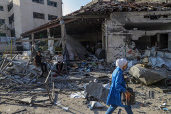 Palestinians inspect destroyed building after Israeli airstrike in Gaza City