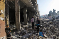 Palestinians inspect destroyed building after Israeli airstrike in Gaza City