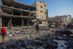 Palestinians inspect destroyed building after Israeli airstrike in Gaza City