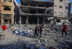 Palestinians inspect destroyed building after Israeli airstrike in Gaza City