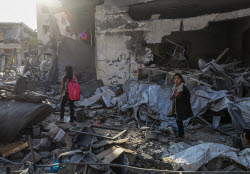 Palestinians inspect destroyed building after Israeli airstrike in Gaza City