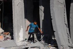Palestinians inspect destroyed building after Israeli airstrike in Gaza City